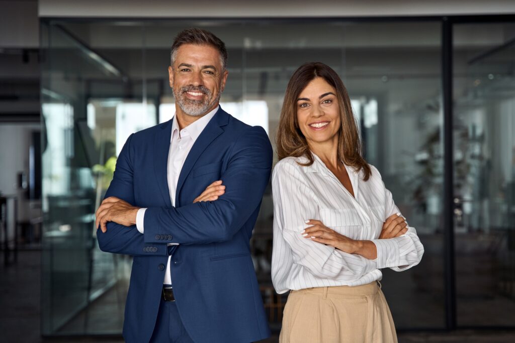 Portrait of smiling mature Latin or Indian business man and European business woman